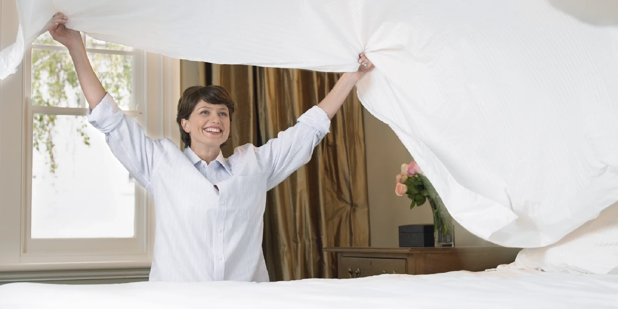 vrouw die bed opmaakt
