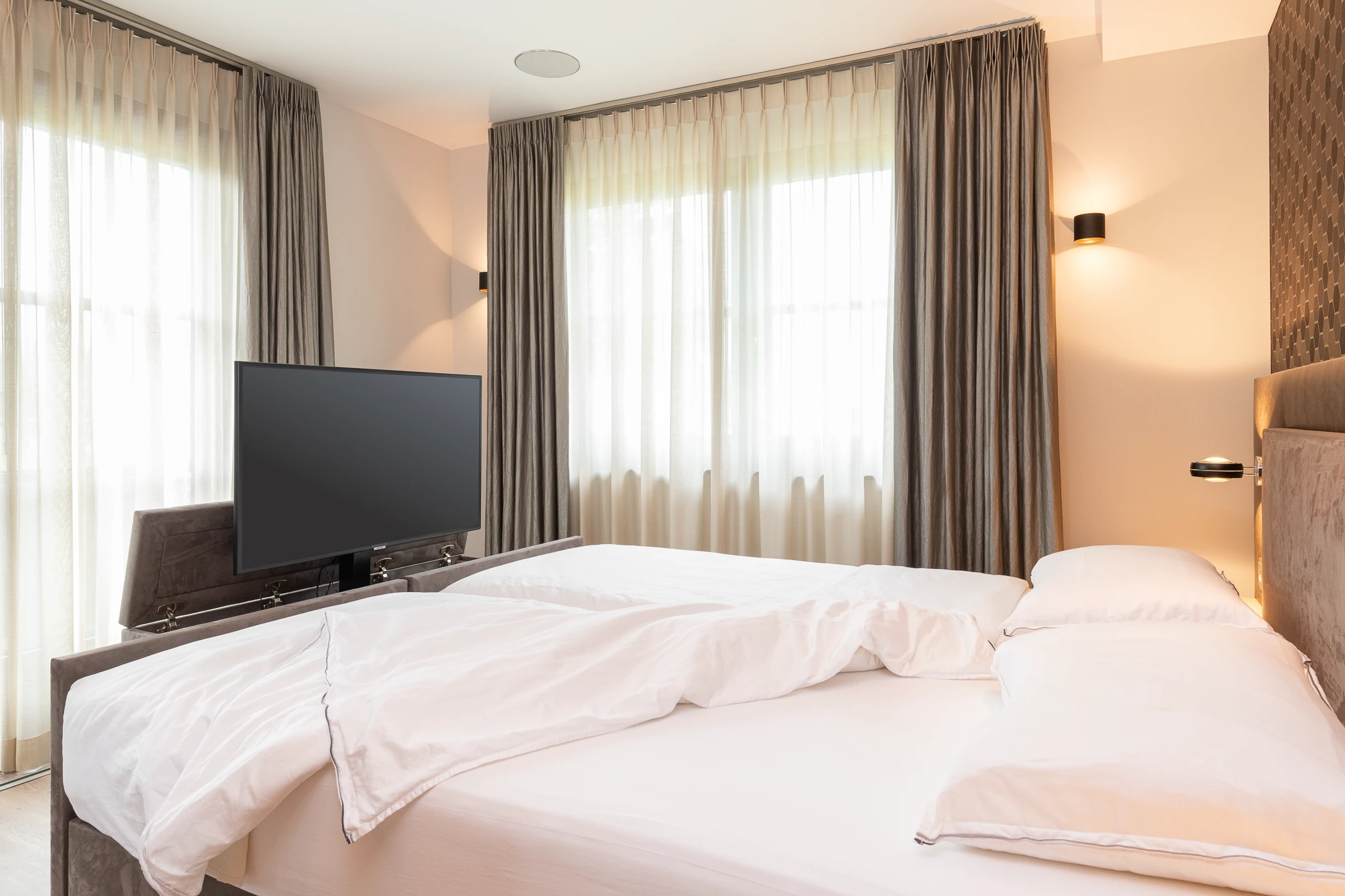 Hotelchique slaapkamer met hoog laag bed